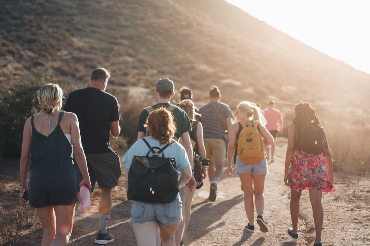 Grupo de senderistas con mochila caminando hacia las montañas